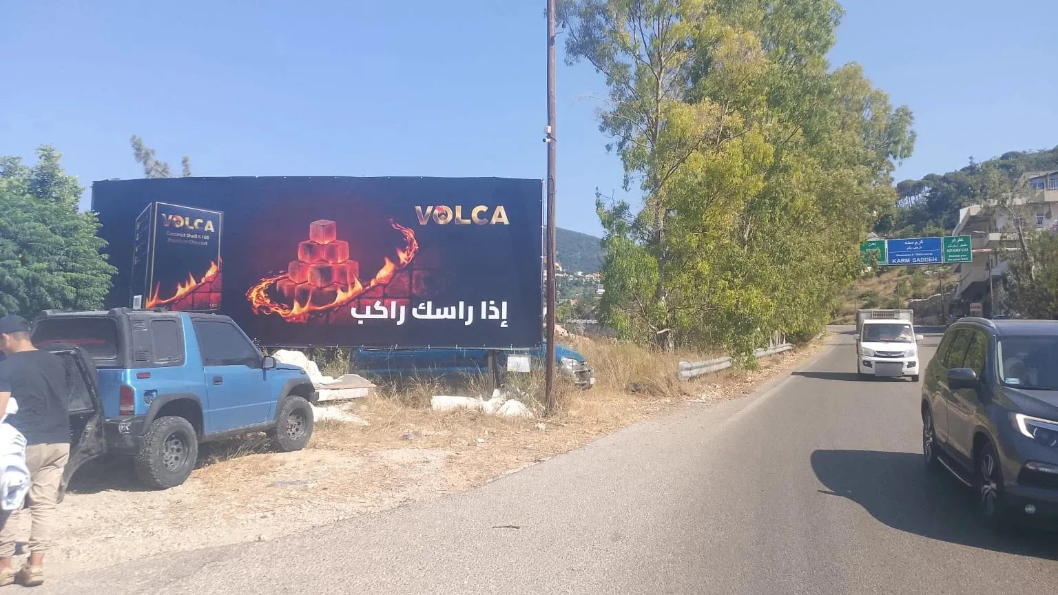 Volca landscape billboard on a road near Karm Saddeh, Zgharta: glowing charcoal cubes, the box and the line إذا راسك راكب
