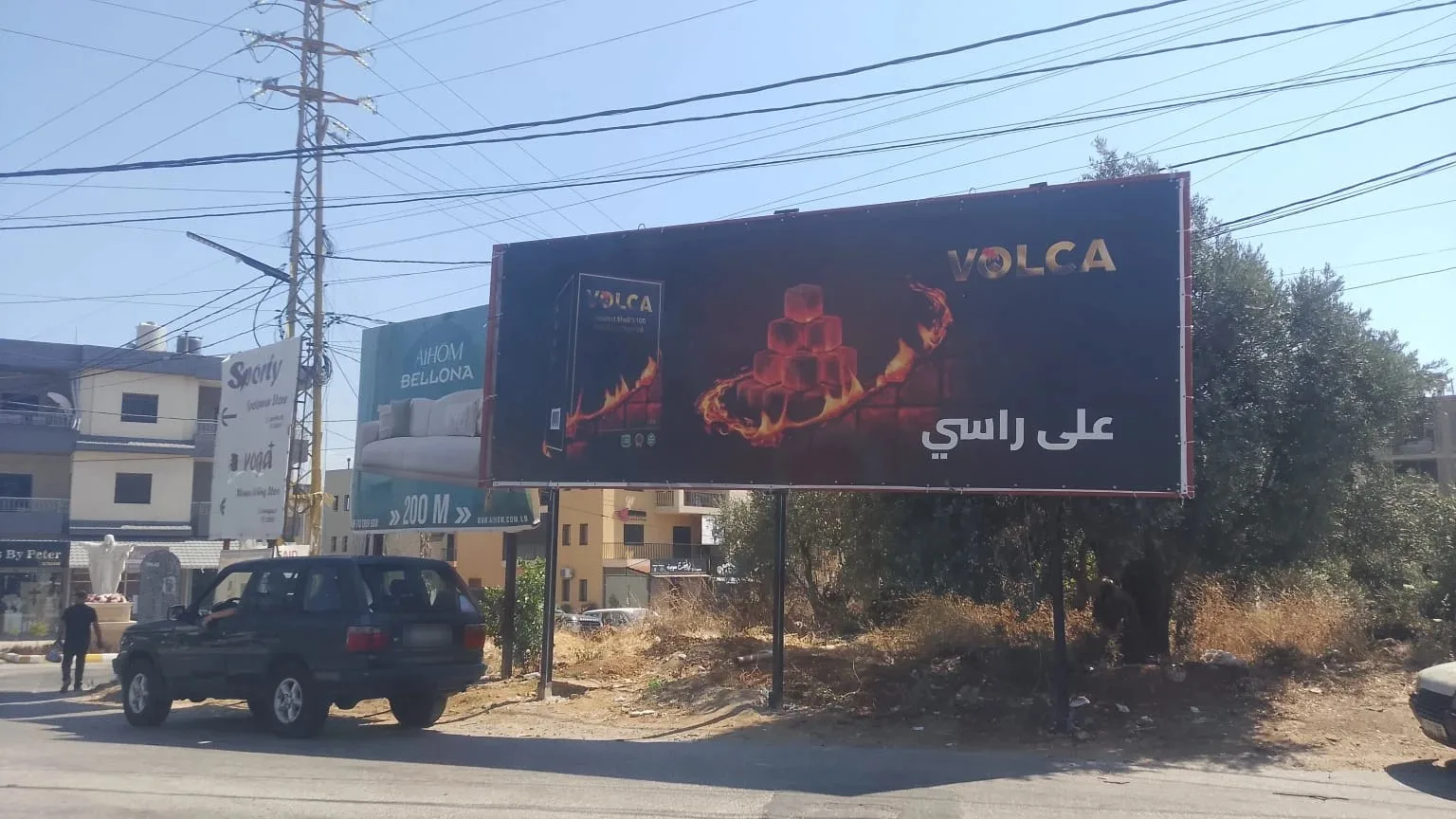 Volca landscape billboard in a Zgharta street with the line على راسي