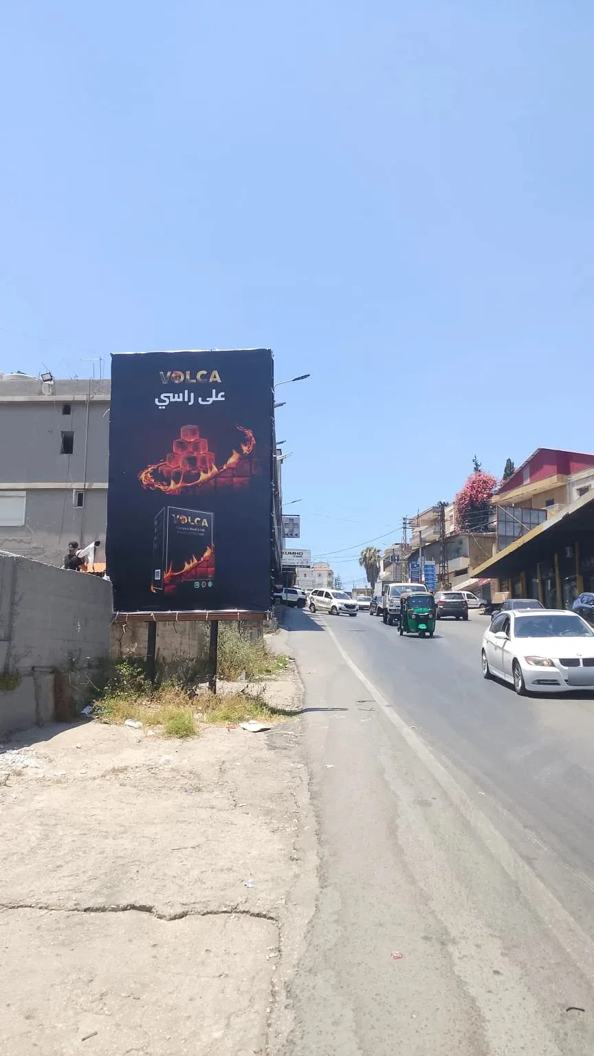 Volca portrait billboard on a busy street, على راسي