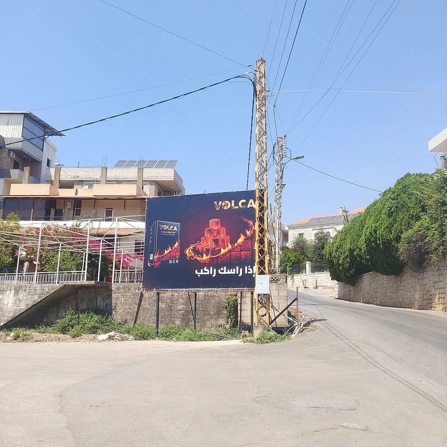 Volca landscape billboard at a village junction, إذا راسك راكب